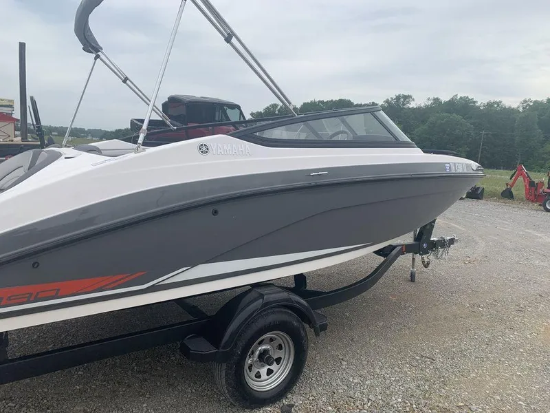 Slide: The Image of 2021 Yamaha Boats SX190 on trailer, gray and white design, parked outdoors. - 0