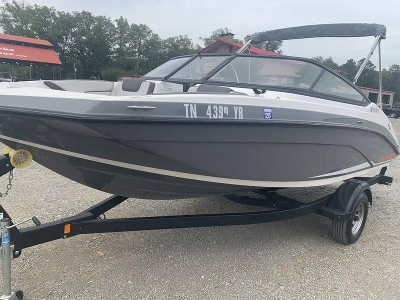 Slide: The Image of 2021 Yamaha Boats SX190 on trailer, gray and white, parked outdoors. - 1
