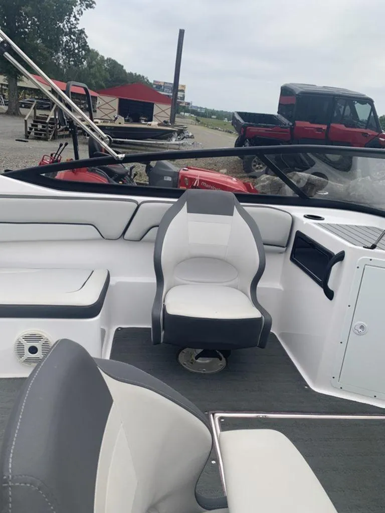 Slide: The Image of 2021 Yamaha Boats SX190 interior with seating and dashboard, parked outdoors. - 5