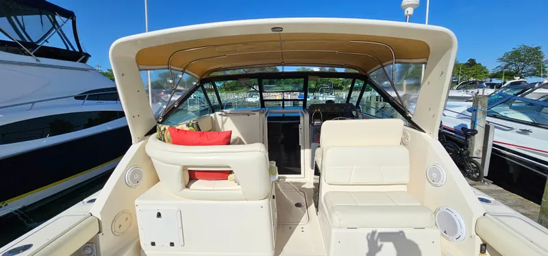Slide: The Image of 1994 Tiara Yachts 3100 Open boat interior with seating and helm, docked under clear blue sky. - 10