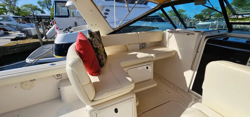 Slide: The Image of 1994 Tiara Yachts 3100 Open interior with seating and cushions, docked at marina. - 14