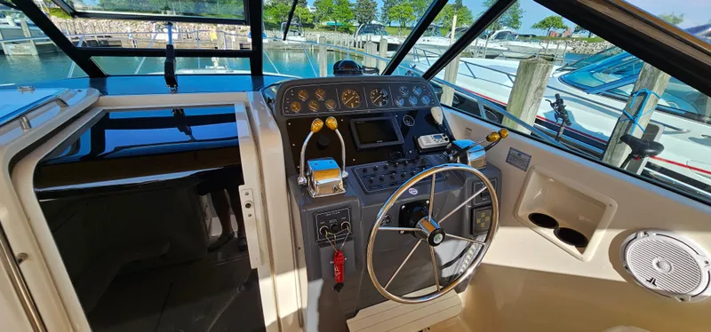 Slide: The Image of 1994 Tiara Yachts 3100 Open helm with steering wheel and control panel, docked at marina. - 15