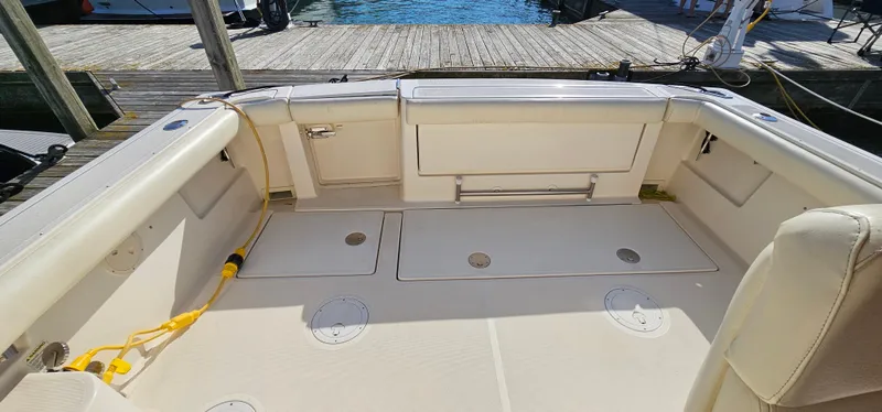 Slide: The Image of 1994 Tiara Yachts 3100 Open boat deck with storage compartments and dock view. - 17