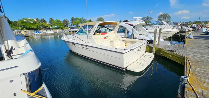 Slide: The Image of 1994 Tiara Yachts 3100 Open docked in a marina under clear blue skies. - 2