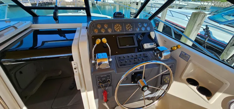 Slide: The Image of 1994 Tiara Yachts 3100 Open helm with steering wheel and control panel. - 20