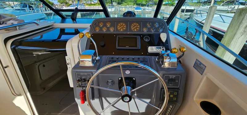 Slide: The Image of 1994 Tiara Yachts 3100 Open helm with steering wheel and control panel. - 21