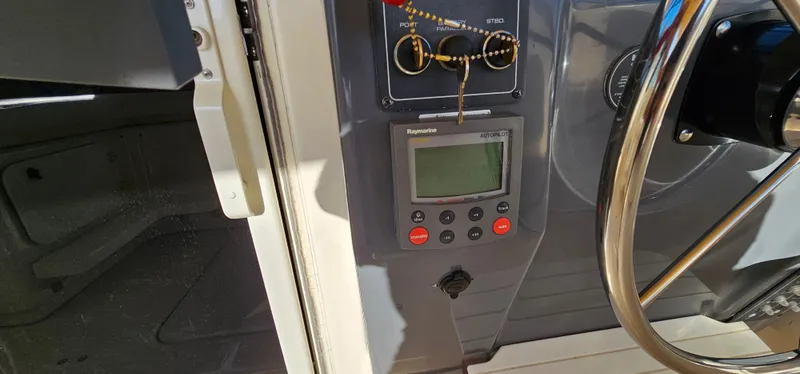 Slide: The Image of 1994 Tiara Yachts 3100 Open dashboard with control panel and steering wheel. - 23