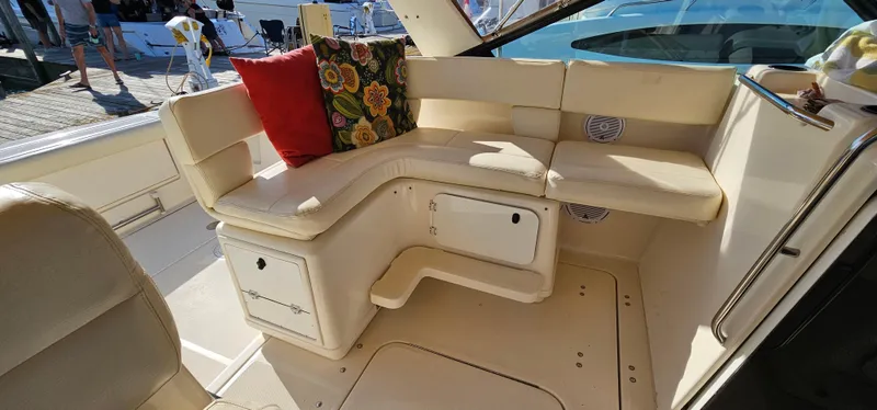 Slide: The Image of 1994 Tiara Yachts 3100 Open interior with cream seating and colorful cushions. - 24