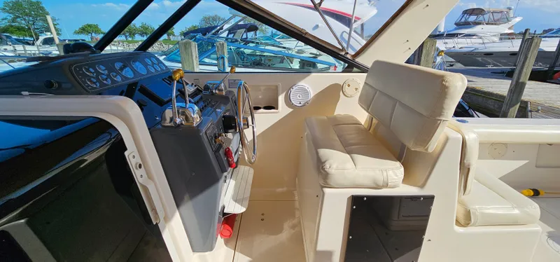 Slide: The Image of 1994 Tiara Yachts 3100 Open helm with beige seating and control panel. - 26