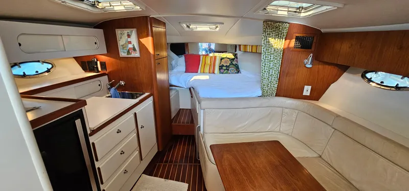 Slide: The Image of 1994 Tiara Yachts 3100 Open interior with cozy seating, kitchenette, and bed. - 29