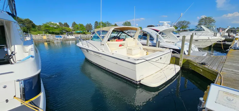 Slide: The Image of 1994 Tiara Yachts 3100 Open docked in a sunny marina setting. - 3