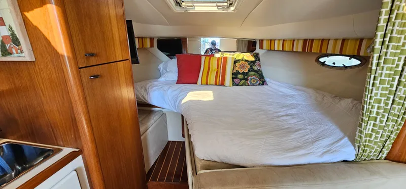 Slide: The Image of 1994 Tiara Yachts 3100 Open cabin interior with cozy bed and colorful pillows. - 31