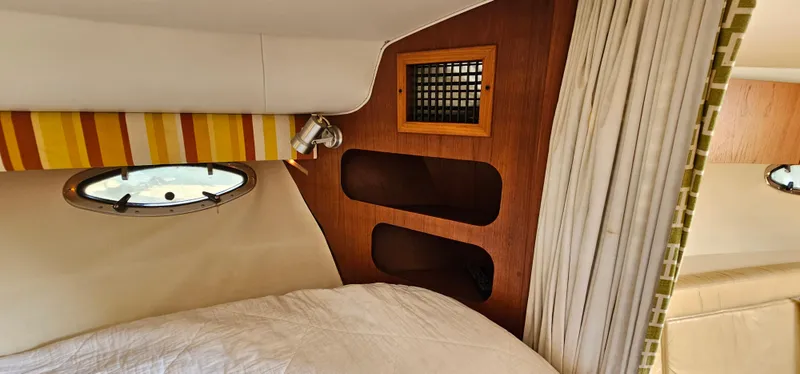 Slide: The Image of Cozy cabin interior of 1994 Tiara Yachts 3100 Open with porthole and wood accents. - 35