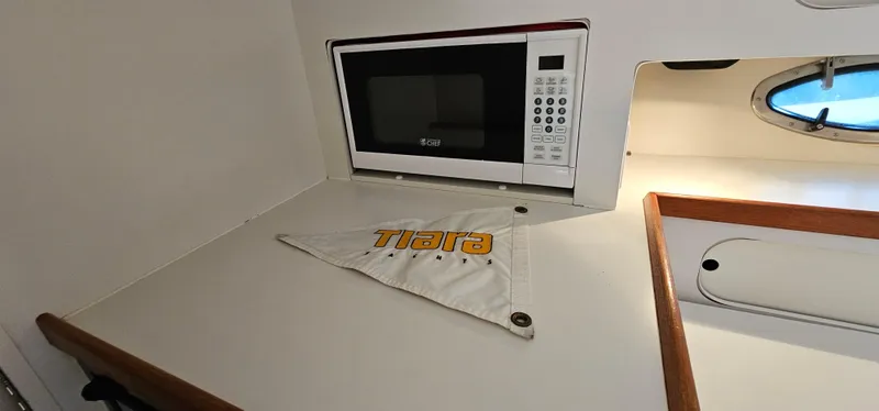 Slide: The Image of 1994 Tiara Yachts 3100 Open interior with microwave and branded cloth on counter. - 39
