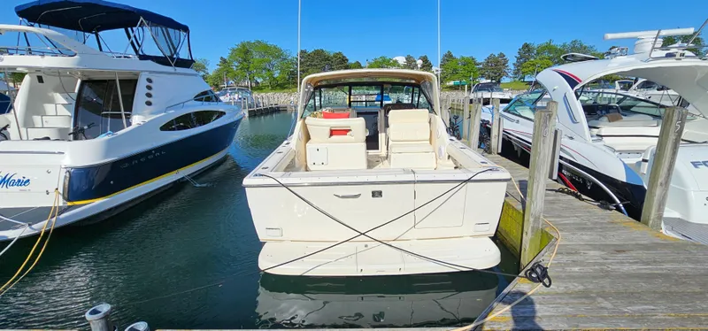 Slide: The Image of 1994 Tiara Yachts 3100 Open docked between boats in a marina. - 5