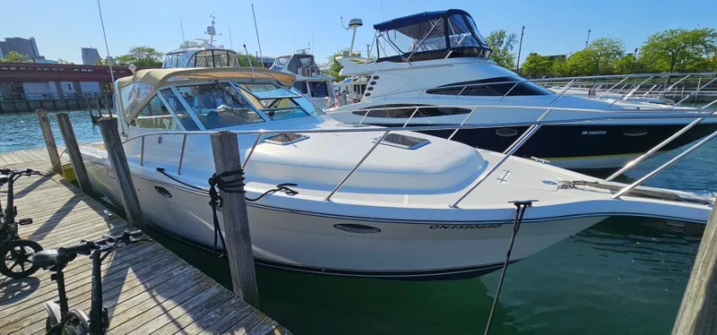 Slide: The Image of 1994 Tiara Yachts 3100 Open docked, showcasing sleek design and spacious deck. - 7