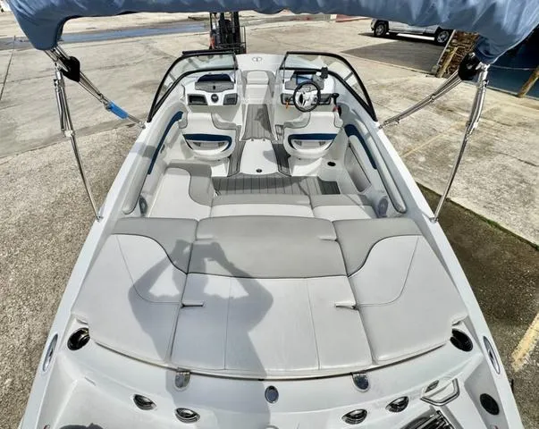 Slide: The Image of 2023 Tahoe 210 Si boat interior with seating and steering wheel, docked outdoors. - 10