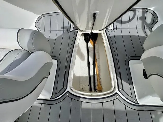 Slide: The Image of 2023 Tahoe 210 Si boat interior with open storage compartment and paddles. - 20