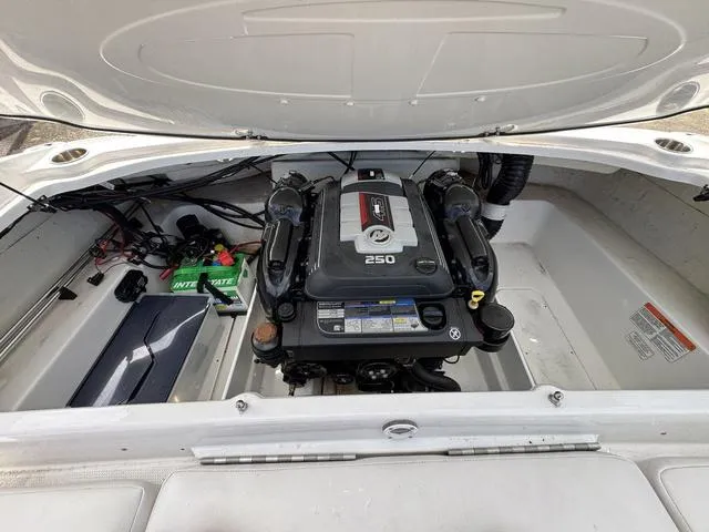 Slide: The Image of 2023 Tahoe 210 Si boat engine compartment with visible Mercury 250 engine and battery. - 21