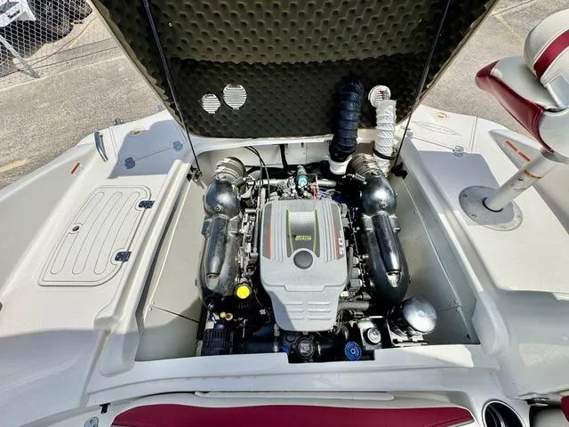 Slide: The Image of 2014 Tahoe 215 Xi boat engine compartment with open hatch, showcasing engine components. - 22