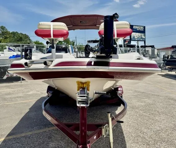 Slide: The Image of 2014 Tahoe 215 Xi boat on trailer, red and white design, parked outdoors. - 4