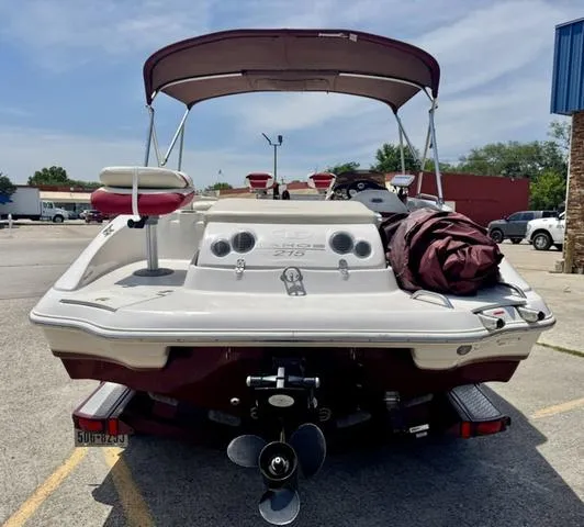 Slide: The Image of 2014 Tahoe 215 Xi boat with canopy, parked in a lot, rear view. - 8