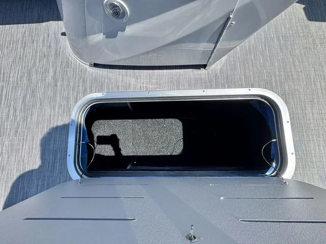 Slide: The Image of 2023 Bennington SX Fish 22 SXFAPG storage compartment with open hatch on deck. - 14