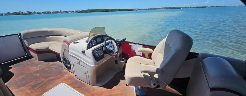Slide: The Image of Pontoon boat interior with beige seating, South Bay 500, 2017 model, on calm blue water. - 17