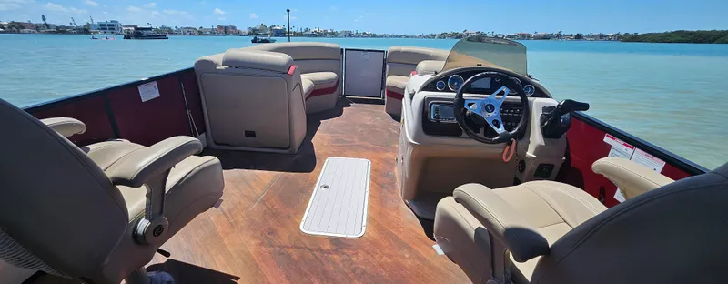 Slide: The Image of 2017 South Bay 500 boat interior with beige seating and steering, on calm blue water. - 21