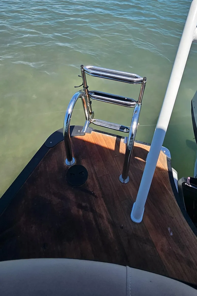 Slide: The Image of 2017 South Bay 500 boat with wooden deck and metal ladder on calm water. - 24