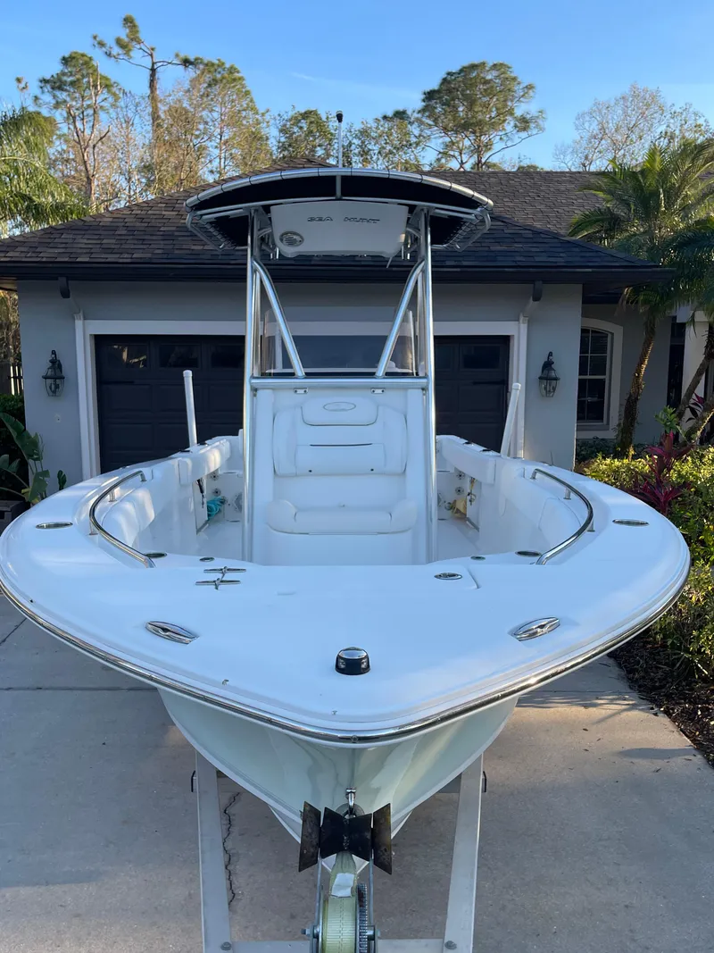 Slide: The Image of 2017 Sea Hunt 225 Ultra boat with trailer, parked in driveway, surrounded by trees. - 14