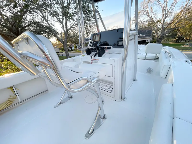 Slide: The Image of 2017 Sea Hunt 225 Ultra boat interior with helm, seating, and controls, featuring 2021 trailer. - 23