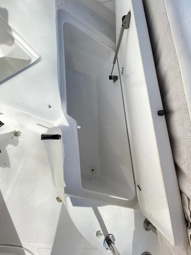 Slide: The Image of 2017 Sea Hunt 225 Ultra storage compartment, open lid, clean interior, white finish. - 24