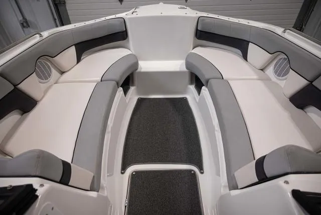 Slide: The Image of 2012 Yamaha Boats 212SS interior with gray and white seating, featuring speakers and carpeted flooring. - 10