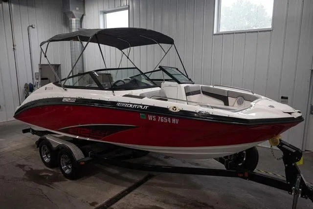 Slide: The Image of 2012 Yamaha Boats 212SS in a garage, featuring a red and white design with a black canopy. - 2