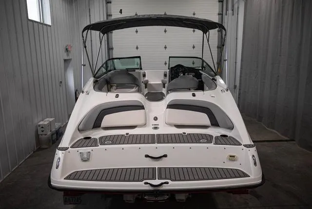 Slide: The Image of 2012 Yamaha Boats 212SS in a garage, rear view with seating and canopy. - 4