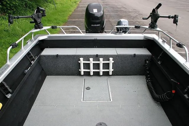 Slide: The Image of 2003 Thunder Jet 19 Luxor boat interior with fishing rod holders and Suzuki outboard motor. - 11