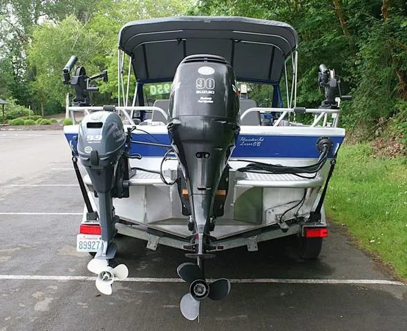 Slide: The Image of 2003 Thunder Jet 19 Luxor boat with dual outboard motors in a parking area. - 4