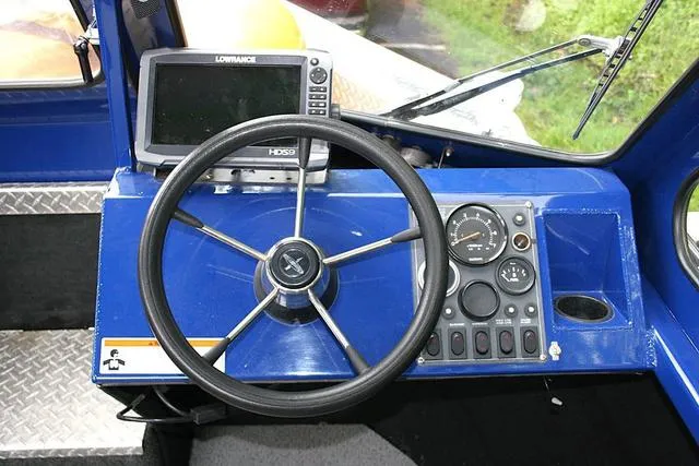 Slide: The Image of 2003 Thunder Jet 19 Luxor boat dashboard with steering wheel and navigation system. - 8