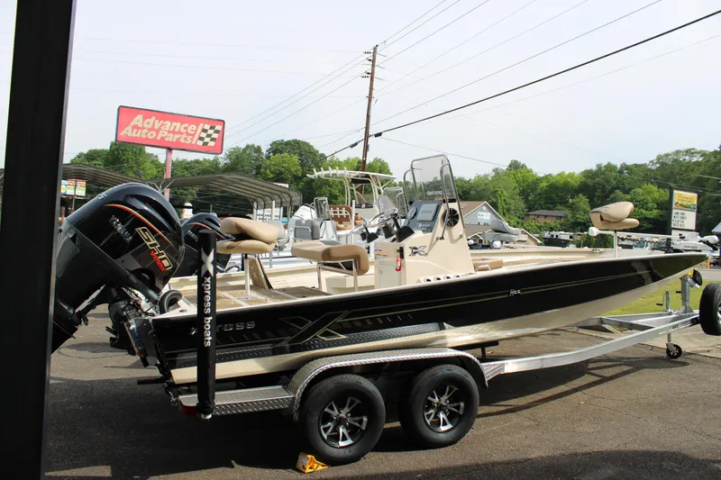 Slide: The Image of 2025 Xpress H22B boat on trailer near Advance Auto Parts store. - 1