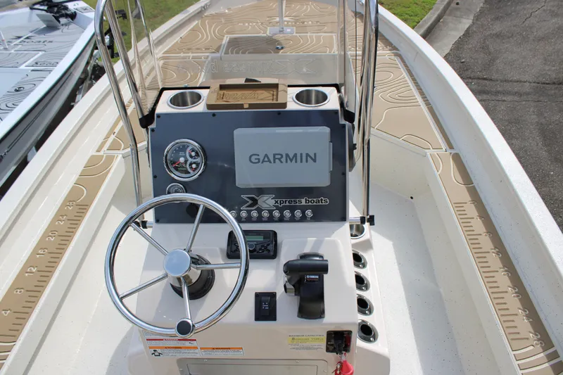 Slide: The Image of 2025 Xpress H22B boat console with Garmin navigation system and steering wheel. - 12