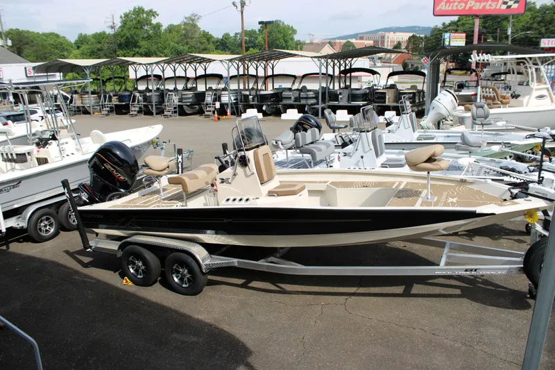 Slide: The Image of 2025 Xpress H22B boat on trailer in dealership lot. - 2
