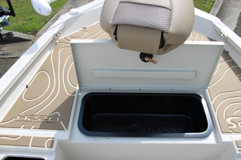 Slide: The Image of 2025 Xpress H22B boat interior with storage compartment and seat. - 5