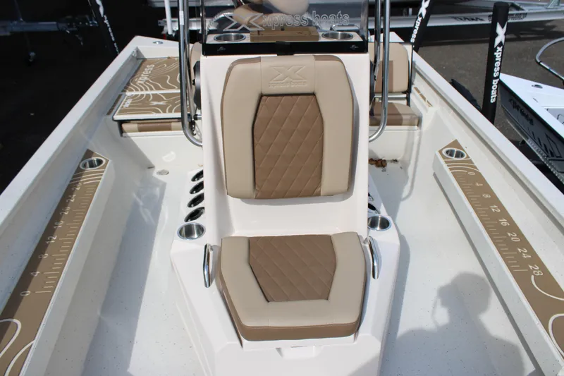 Slide: The Image of 2025 Xpress H22B boat interior with tan cushioned seating and measuring guides. - 7