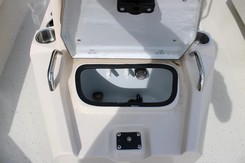 Slide: The Image of Open storage compartment on 2025 Xpress H22B boat, featuring stainless steel handles. - 8