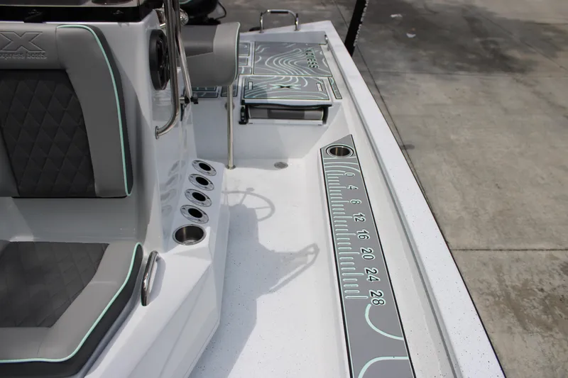 Slide: The Image of 2025 Xpress H22B boat interior with seating, rod holders, and measuring ruler on deck. - 15
