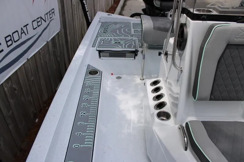 Slide: The Image of 2025 Xpress H22B boat interior with seating, rod holders, and measuring ruler on deck. - 16