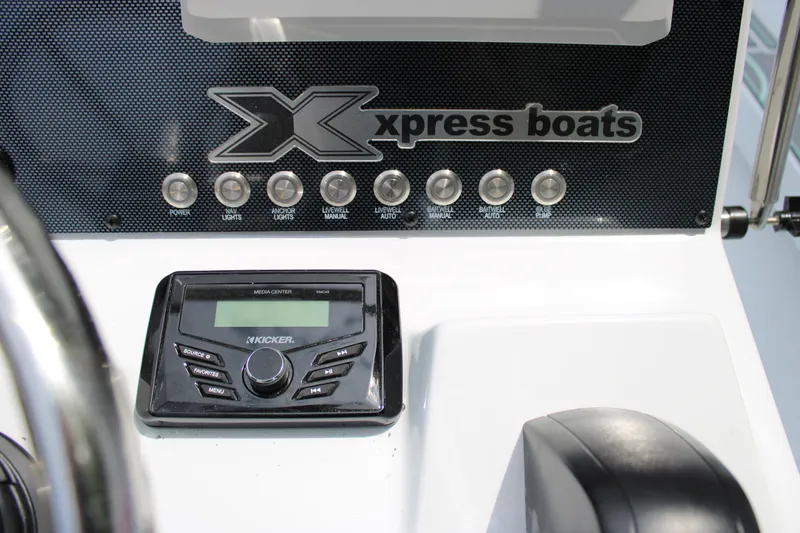 Slide: The Image of Control panel of 2025 Xpress H22B boat with audio system and switches. - 19