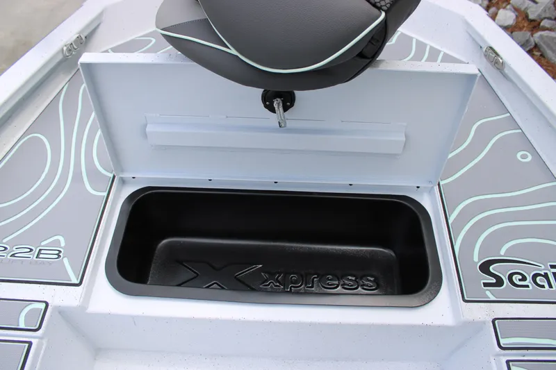 Slide: The Image of 2025 Xpress H22B boat storage compartment with seat and logo detailing. - 7