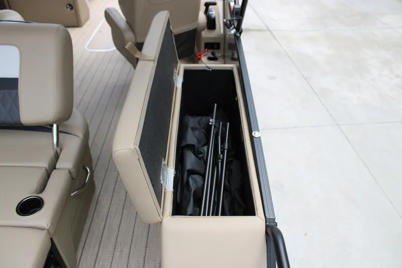 Slide: The Image of 2025 Starcraft SLS-3 Q DH boat storage compartment with beige seating and fishing rod holder. - 23